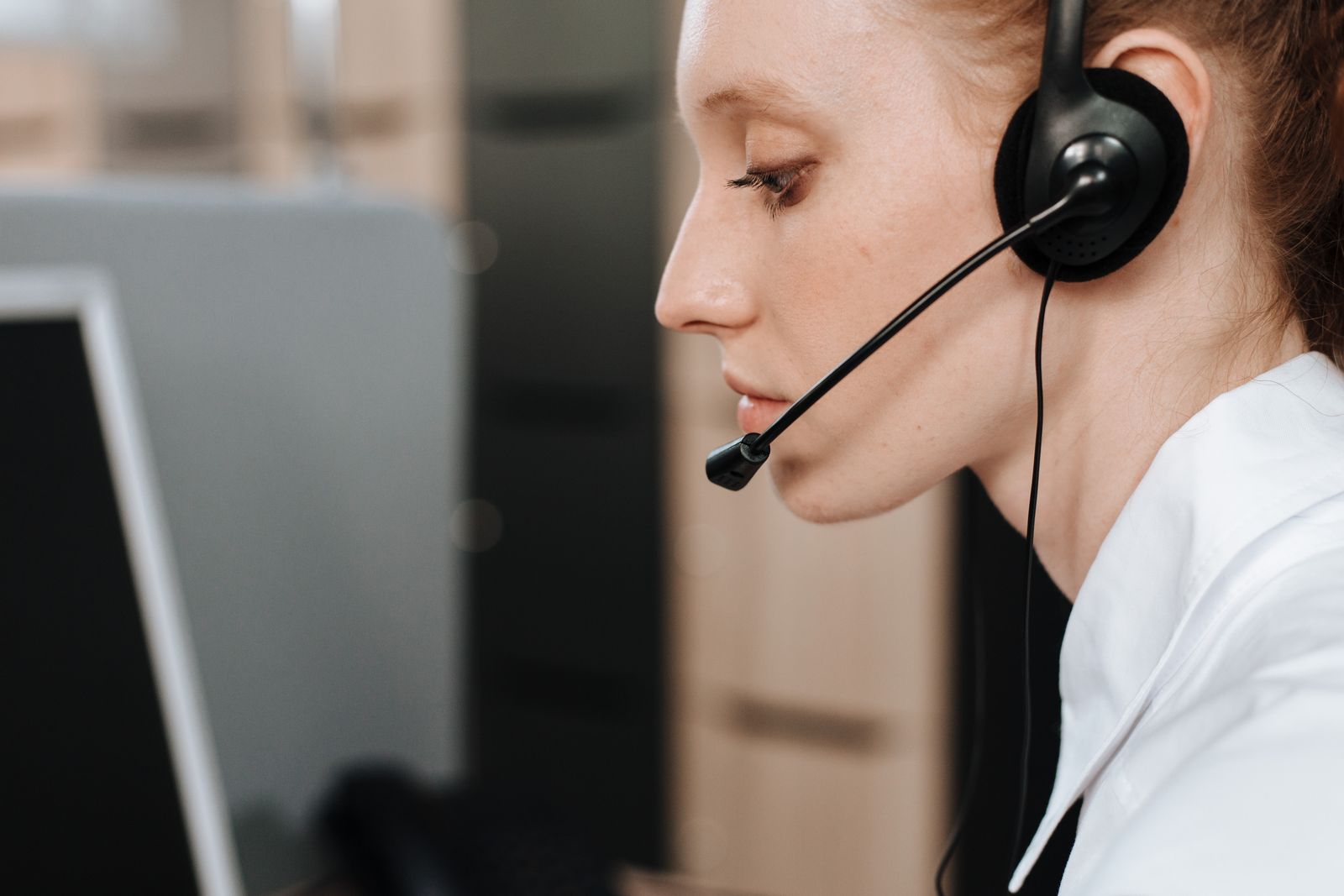 Support agent wearing a headset reviewing a call at her desk